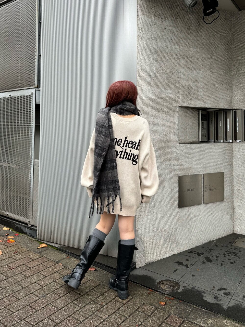 ホワイト系のニット/セーター、ブラック系のブーツ、グレー系のマフラーを着用したレディースの秋コーディネートの2枚目の写真