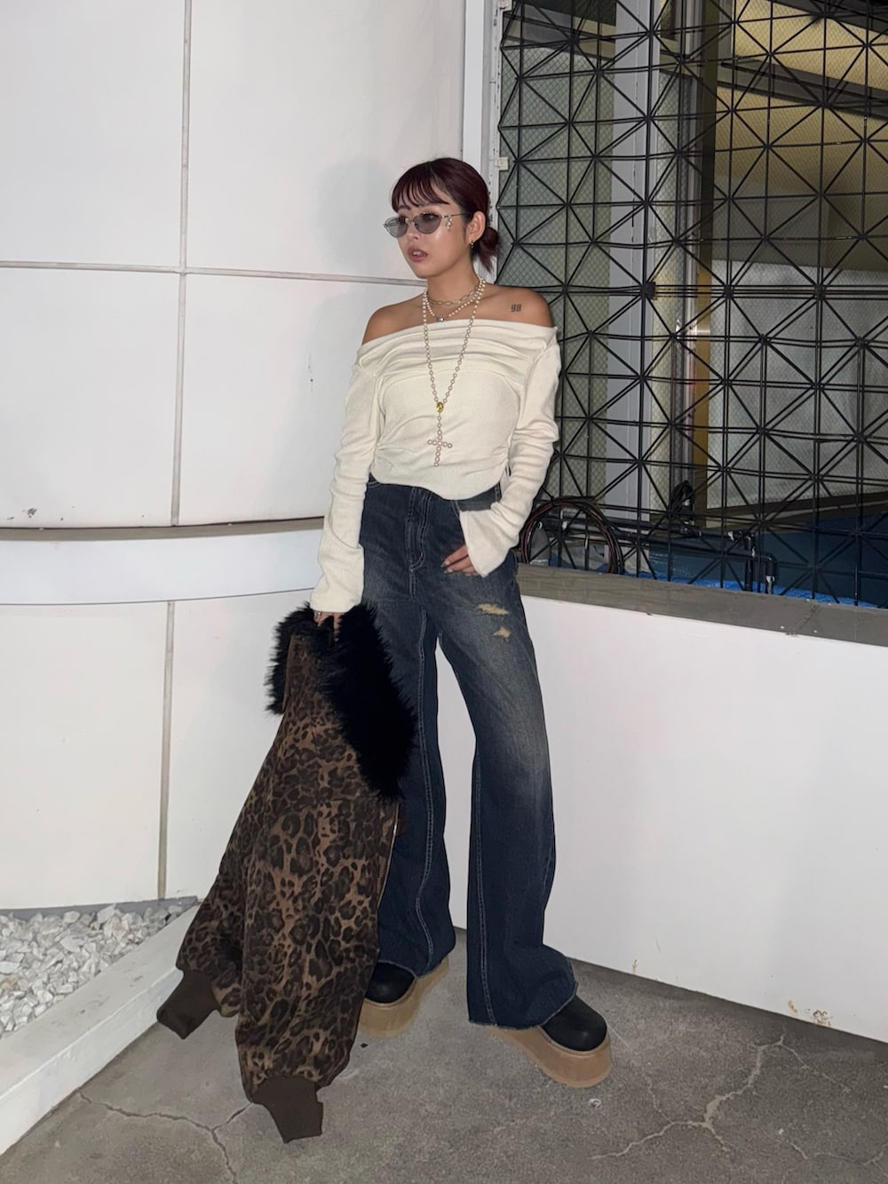 ホワイト系のニット/セーター、ブルー系のデニムパンツ、ブラック系のスリッポンを着用したレディースの秋コーディネートの2枚目の写真