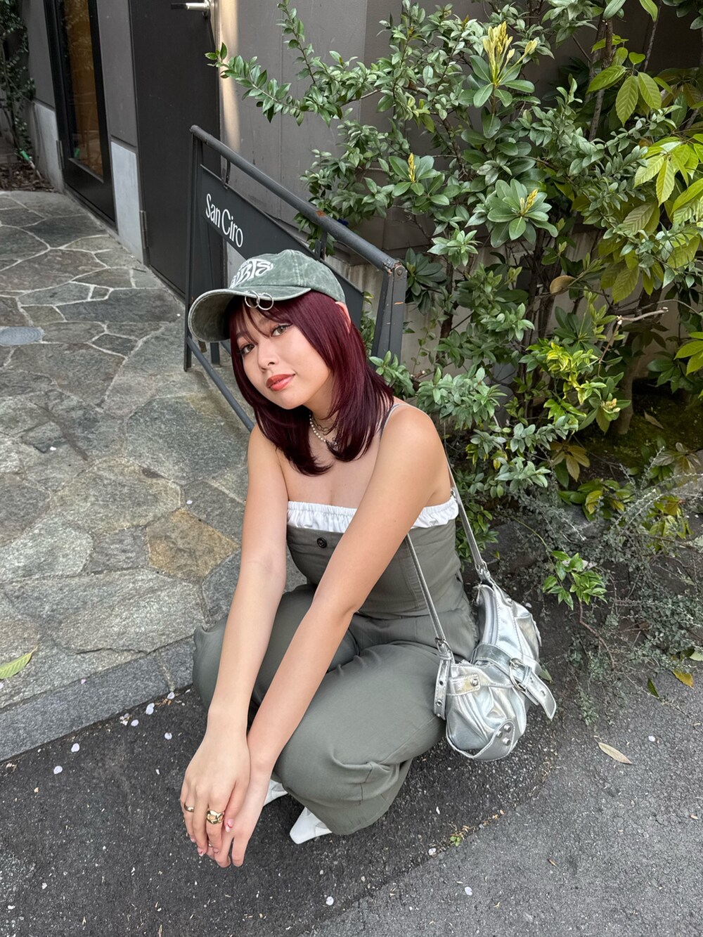 グリーン系のつなぎ/オールインワン、ホワイト系のパンプス、グリーン系のキャップを着用したレディースの春コーディネートの5枚目の写真