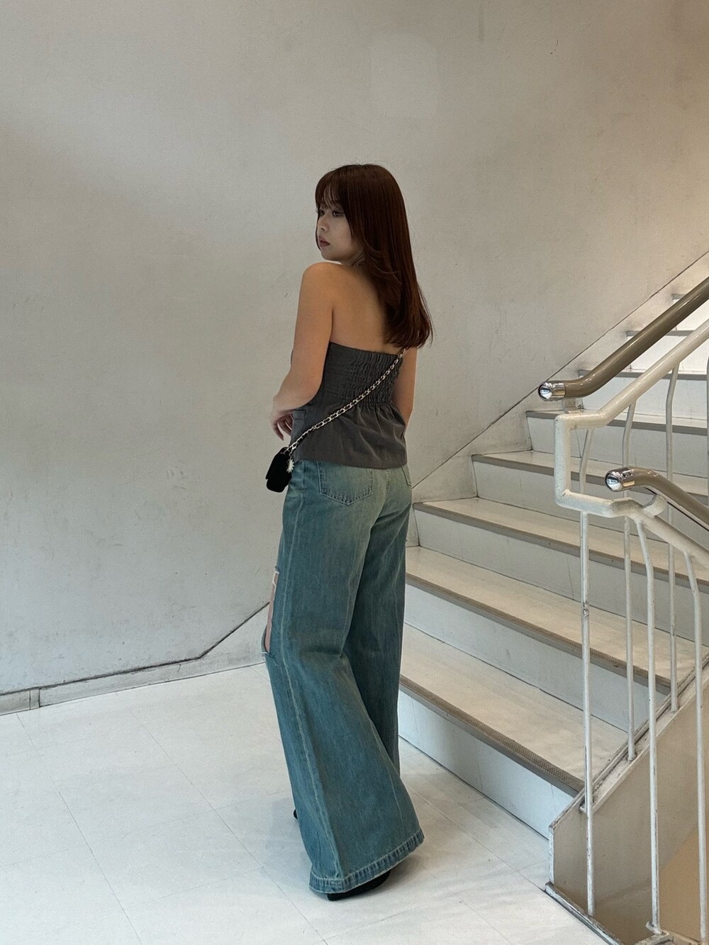 グレー系のキャミソール、ブラック系のブーツ、ブラック系のショルダーバッグを着用したレディースの春コーディネートの2枚目の写真