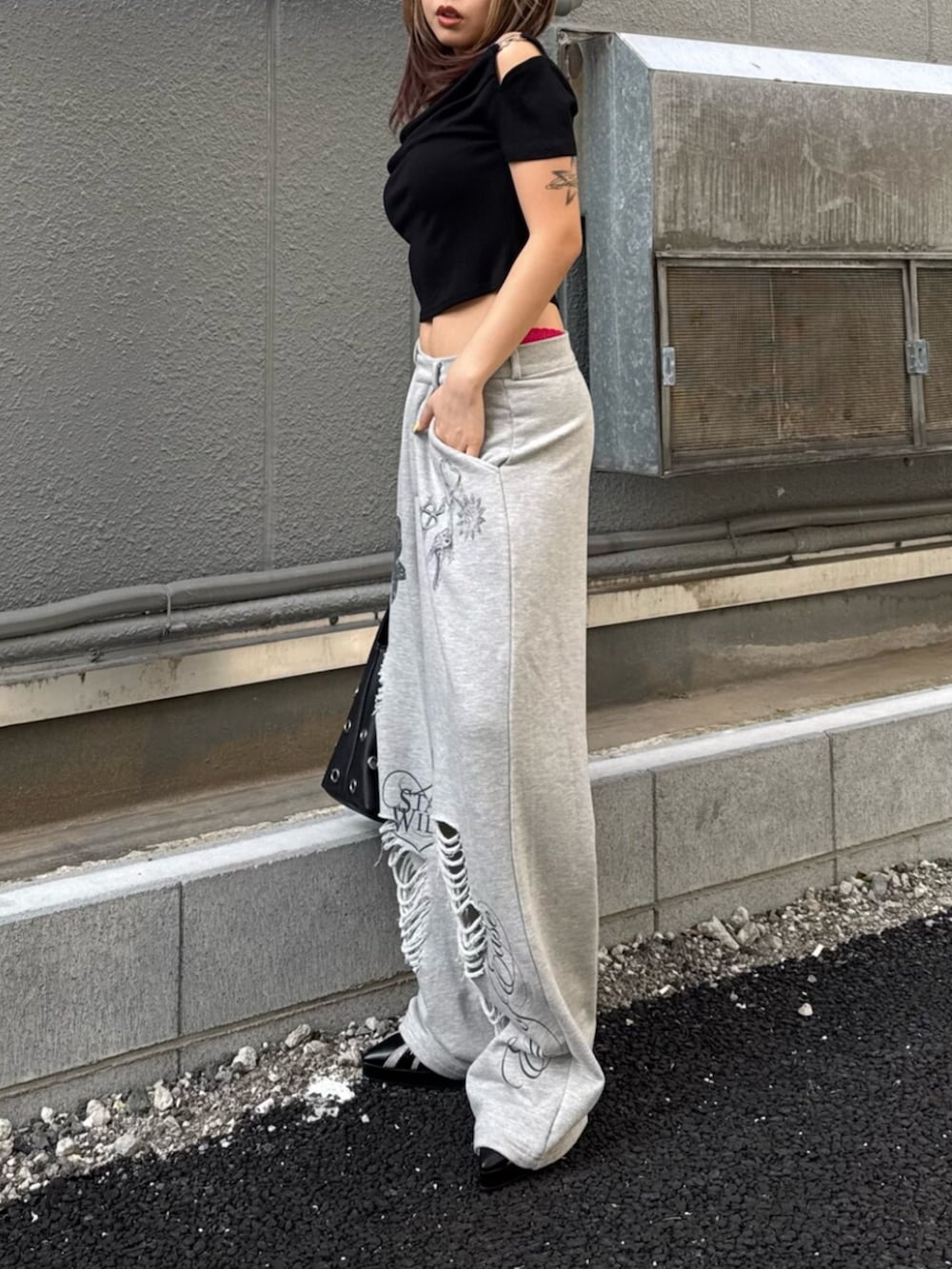 ブラック系のサンダル、ブラック系のTシャツ/カットソー、グレー系のスウェットパンツを着用したレディースの夏コーディネートの2枚目の写真