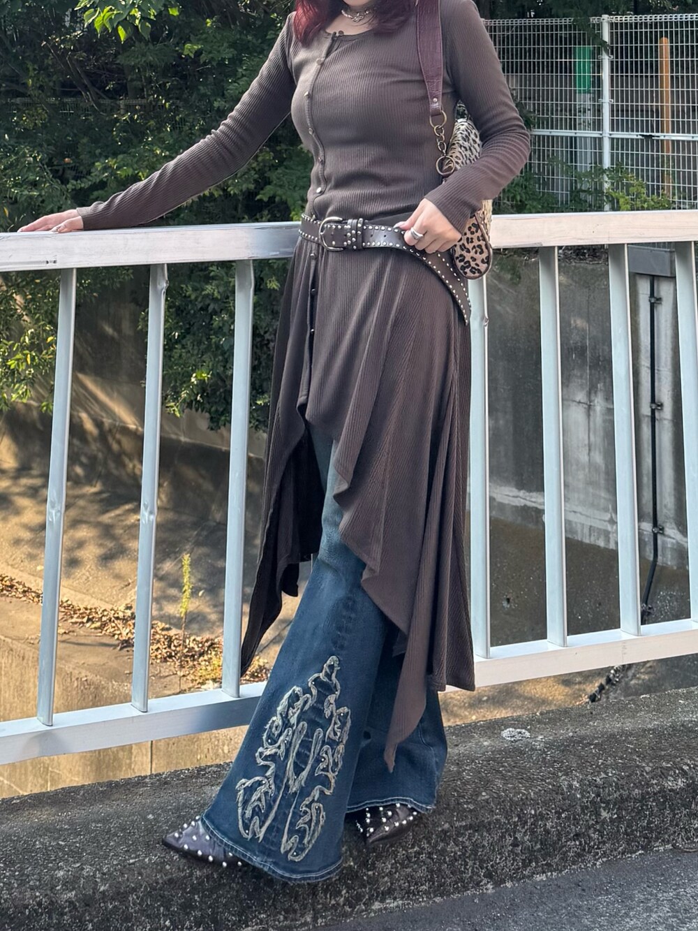 ブルー系のデニムパンツ、ベージュ系のハンドバッグを着用したレディースの秋コーディネートの3枚目の写真