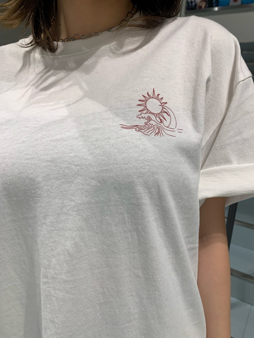 ホワイト系のTシャツ/カットソー、ホワイト系のハンドバッグ、ブラック系のブーツを着用したレディースの春コーディネートの4枚目の写真