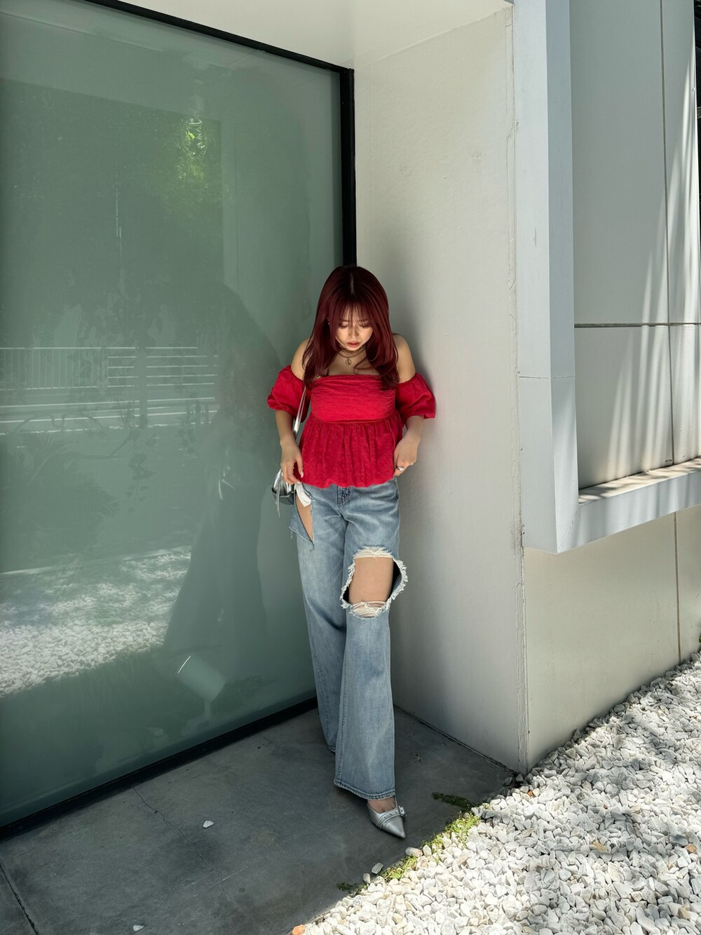 レッド系のシャツ/ブラウス、ブルー系のデニムパンツを着用したレディースの夏コーディネートの2枚目の写真