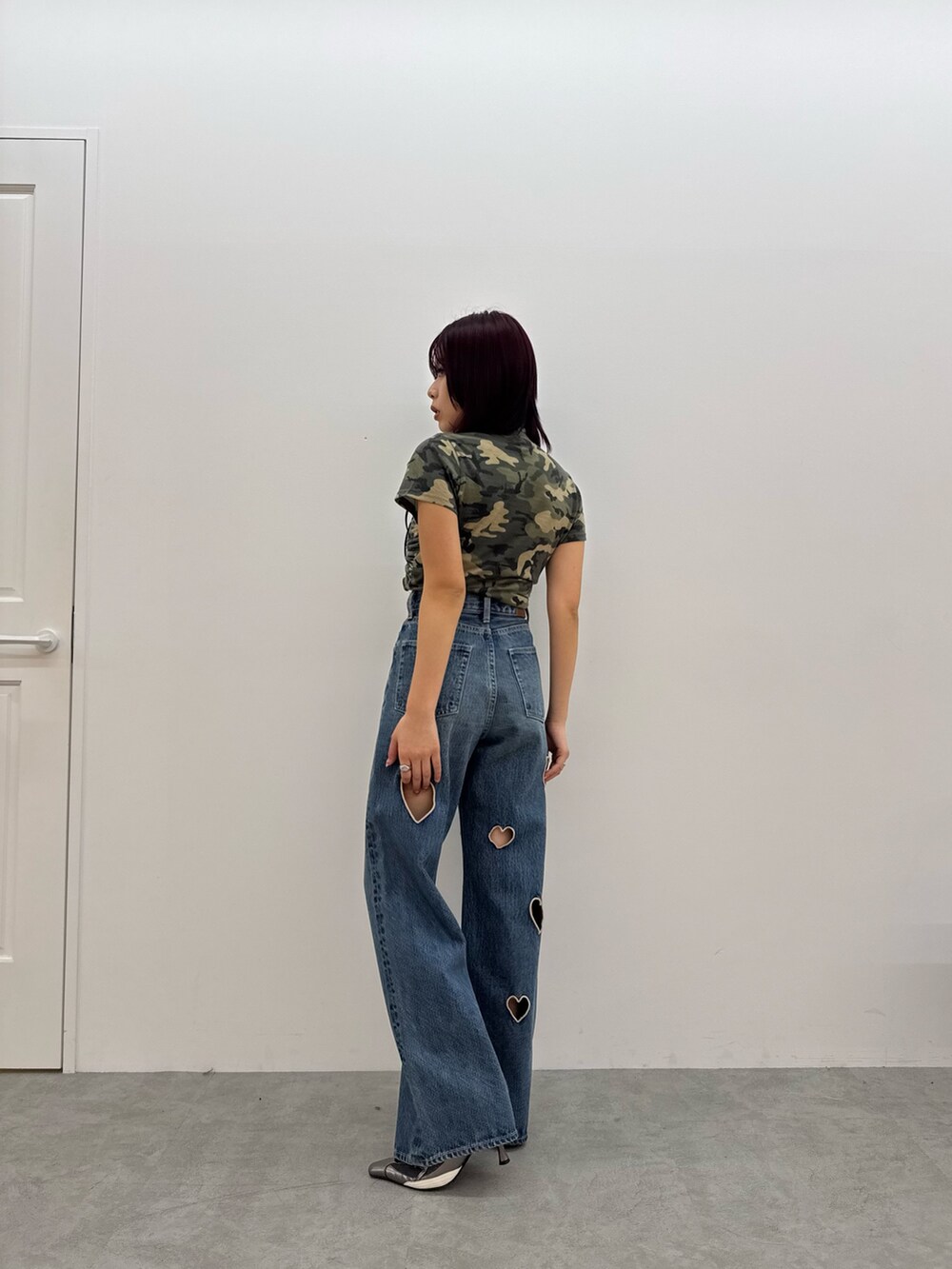 グリーン系のTシャツ/カットソー、ブルー系のデニムパンツ、シルバー系のパンプスを着用したレディースの春コーディネートの3枚目の写真