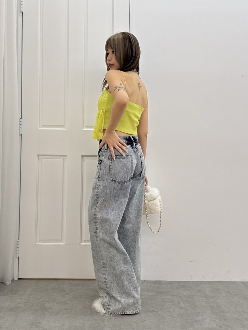ホワイト系のサンダル、ブルー系のデニムパンツ、ホワイト系のショルダーバッグを着用したレディースの夏コーディネートの2枚目の写真
