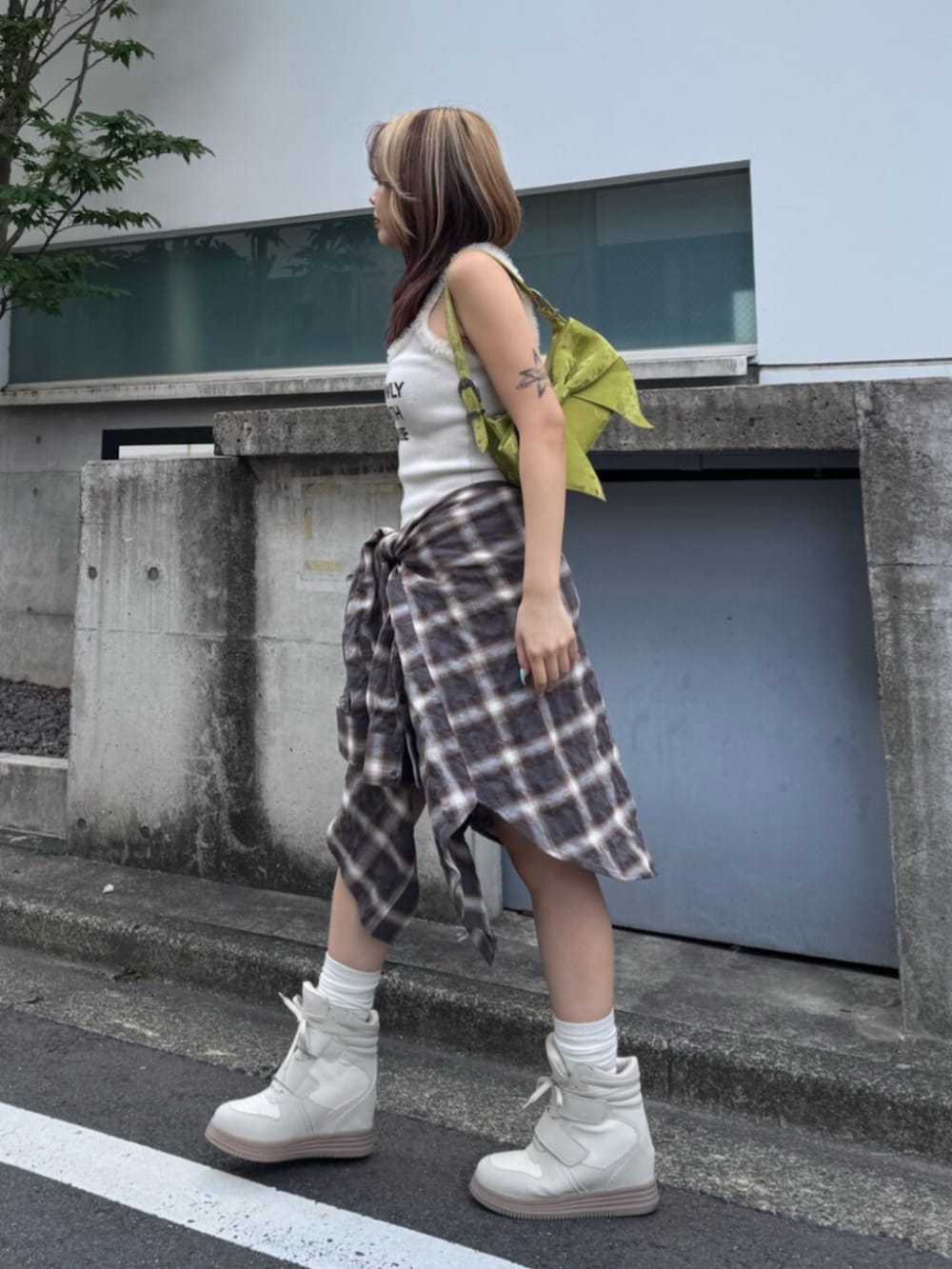 ホワイト系のワンピース、ホワイト系のスニーカー、グリーン系のハンドバッグを着用したレディースの夏コーディネートの2枚目の写真