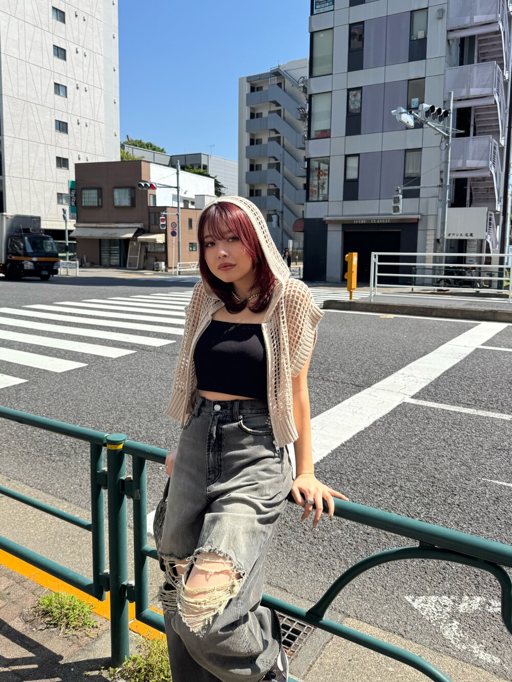 ホワイト系のニット/セーター、ブラック系のキャミソール、ブラック系のデニムパンツを着用したレディースの春コーディネートの3枚目の写真