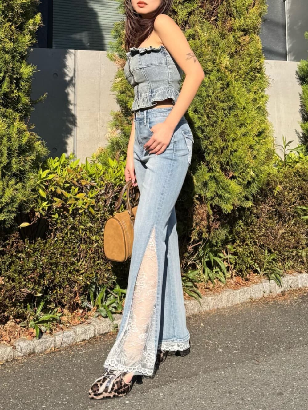 ブルー系のその他トップス、ブルー系のデニムパンツ、ブラウン系のボストンバッグを着用したレディースの春コーディネートの2枚目の写真
