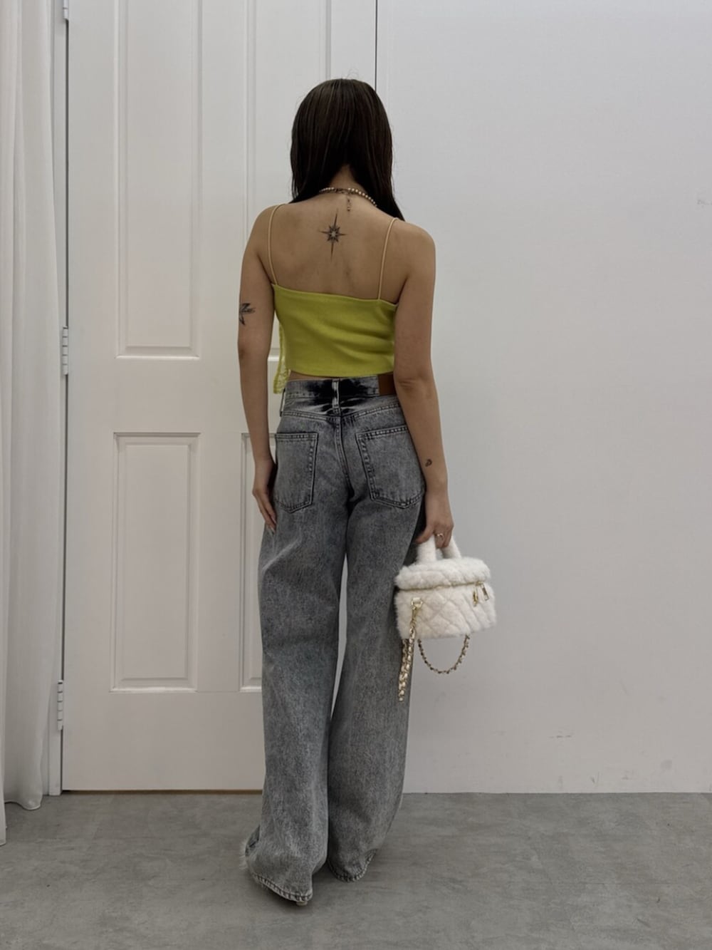 ホワイト系のサンダル、ブルー系のデニムパンツ、ホワイト系のショルダーバッグを着用したレディースの夏コーディネートの3枚目の写真