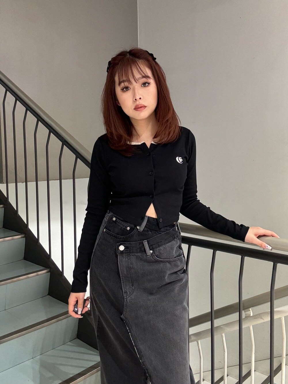 ブラック系のTシャツ/カットソー、ブラック系のデニムスカートを着用したレディースの冬コーディネートの4枚目の写真