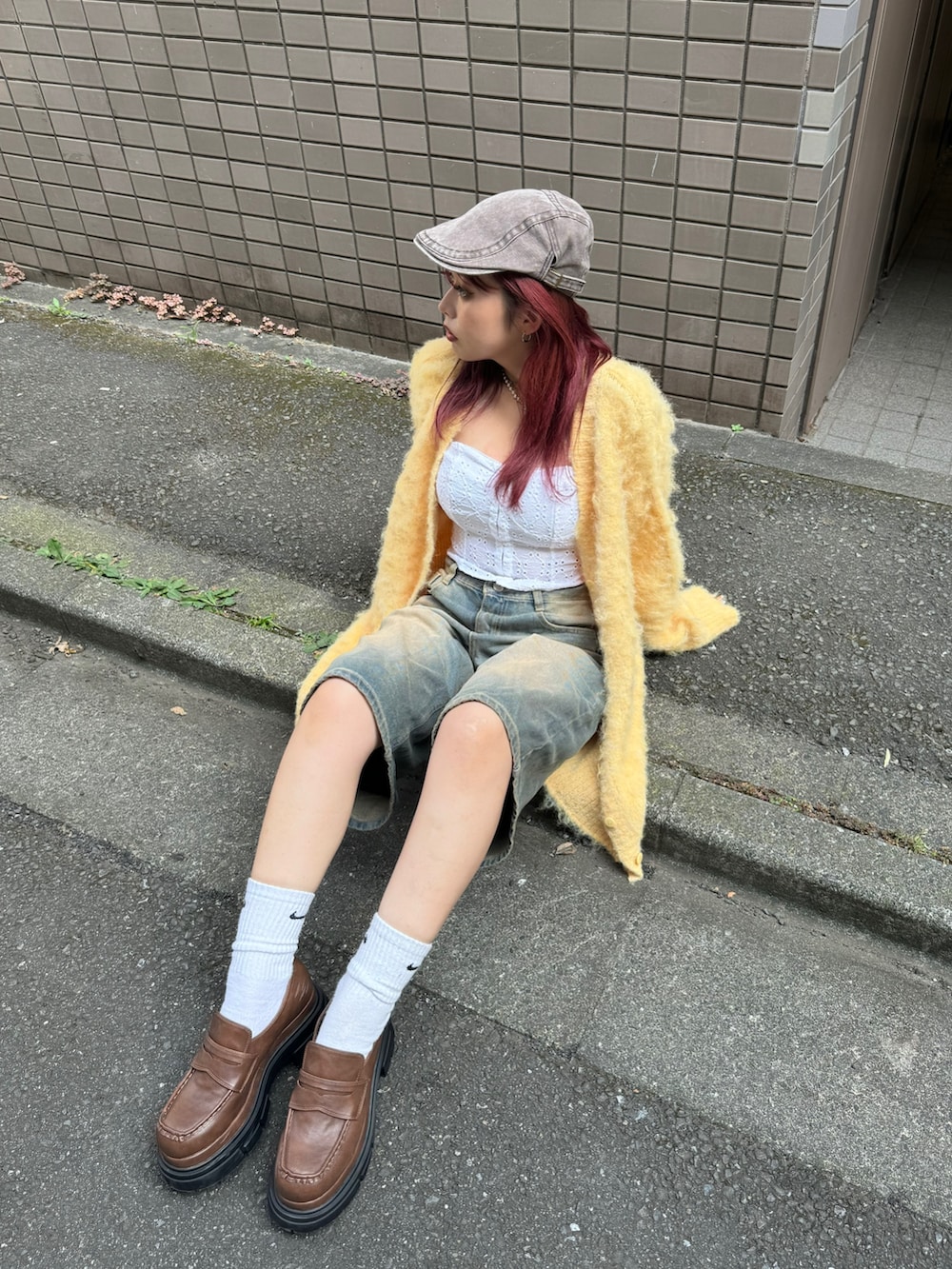 イエロー系のニット/セーター、ブラウン系のローファーを着用したレディースの夏コーディネートの3枚目の写真