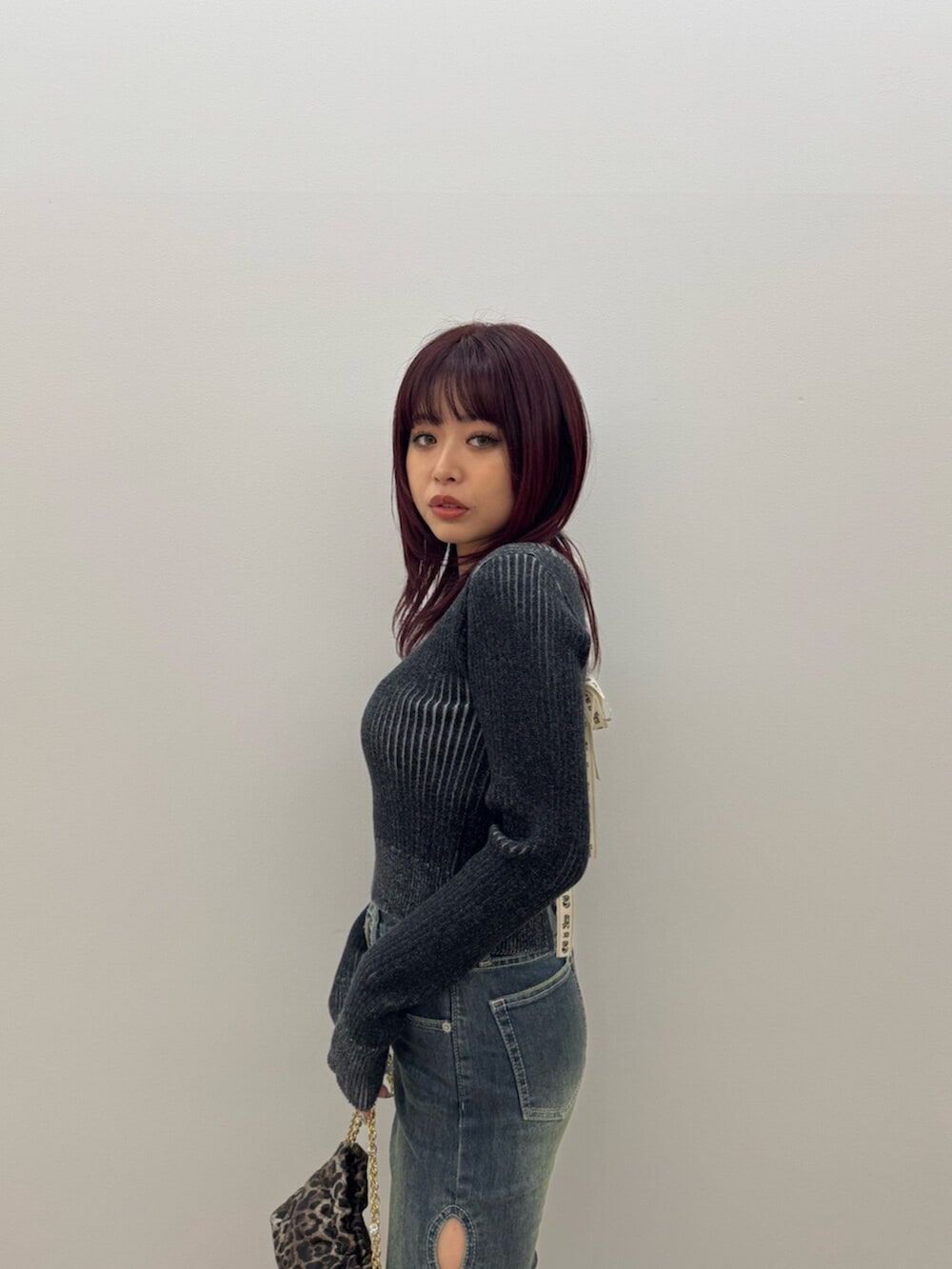 ブラック系のブーツ、ブラック系のニット/セーター、ブルー系のデニムパンツを着用したレディースの冬コーディネートの4枚目の写真