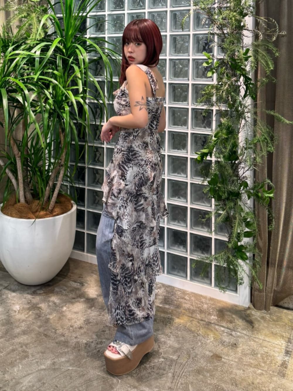 ベージュ系のワンピース、ブルー系のデニムパンツ、ホワイト系のサンダルを着用したレディースの春コーディネートの2枚目の写真