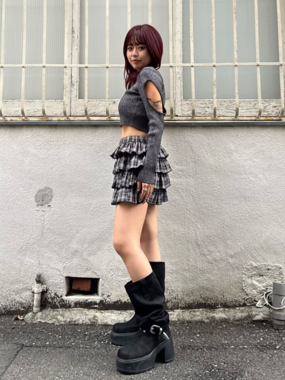 ブラック系のブーツ、ブラック系のスカート、ブラック系のニット/セーターを着用したレディースの秋コーディネートの2枚目の写真