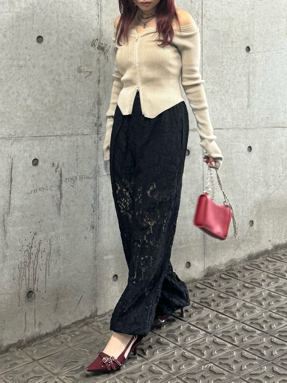 ベージュ系のニット/セーター、ブラック系のその他パンツ、レッド系のショルダーバッグを着用したレディースの夏コーディネートの2枚目の写真