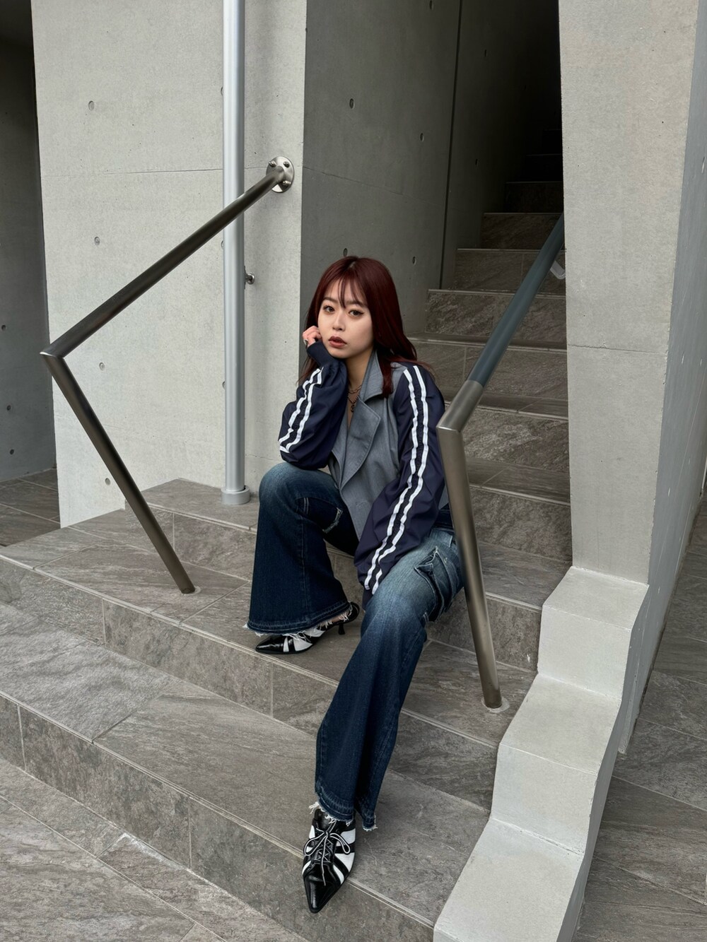 グレー系のテーラードジャケット、ブルー系のデニムパンツ、ブラック系のサンダルを着用したレディースの冬コーディネートの2枚目の写真