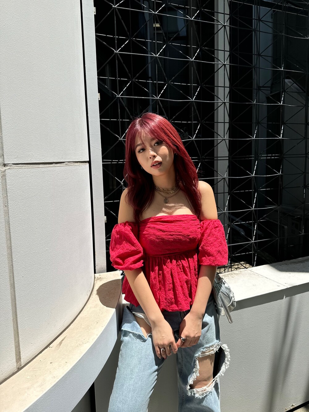 レッド系のシャツ/ブラウス、ブルー系のデニムパンツを着用したレディースの夏コーディネートの3枚目の写真