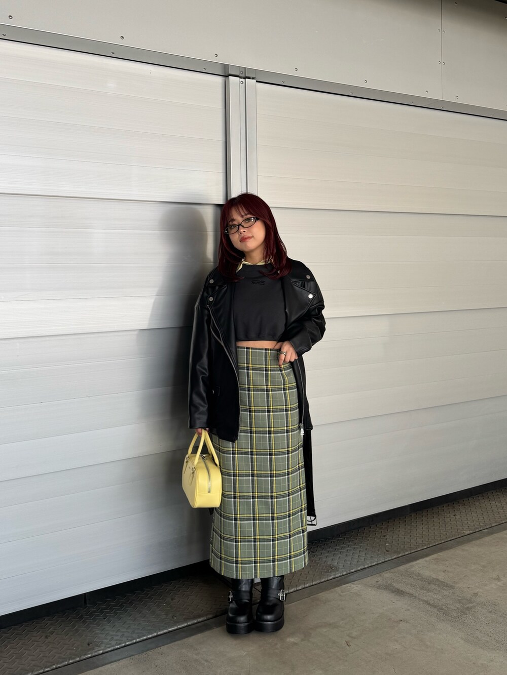 イエロー系のシャツ/ブラウス、ブラック系のスウェット、ブラック系のライダースジャケットを着用したレディースの冬コーディネートの2枚目の写真