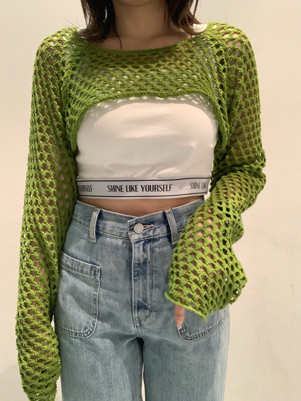 ホワイト系のサンダル、ブルー系のデニムパンツ、ホワイト系のキャミソールを着用したレディースの春コーディネートの4枚目の写真