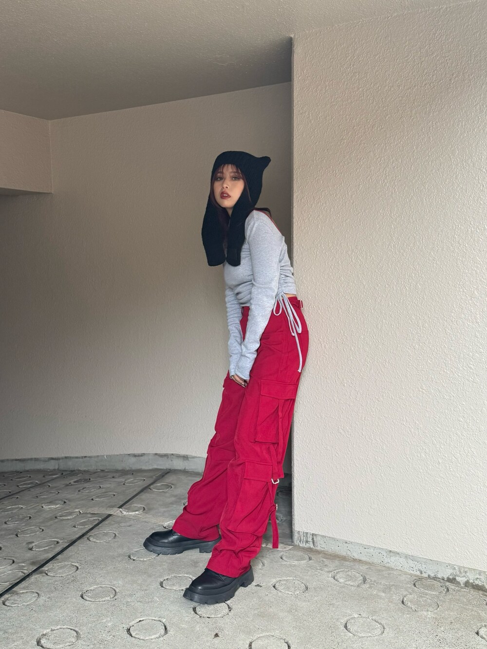 グレー系のTシャツ/カットソー、レッド系のカーゴパンツ、ブラック系のブーツを着用したレディースの秋コーディネートの3枚目の写真