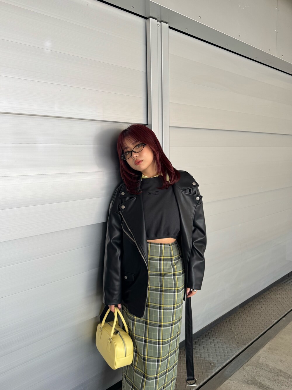 イエロー系のシャツ/ブラウス、ブラック系のスウェット、ブラック系のライダースジャケットを着用したレディースの冬コーディネートの7枚目の写真