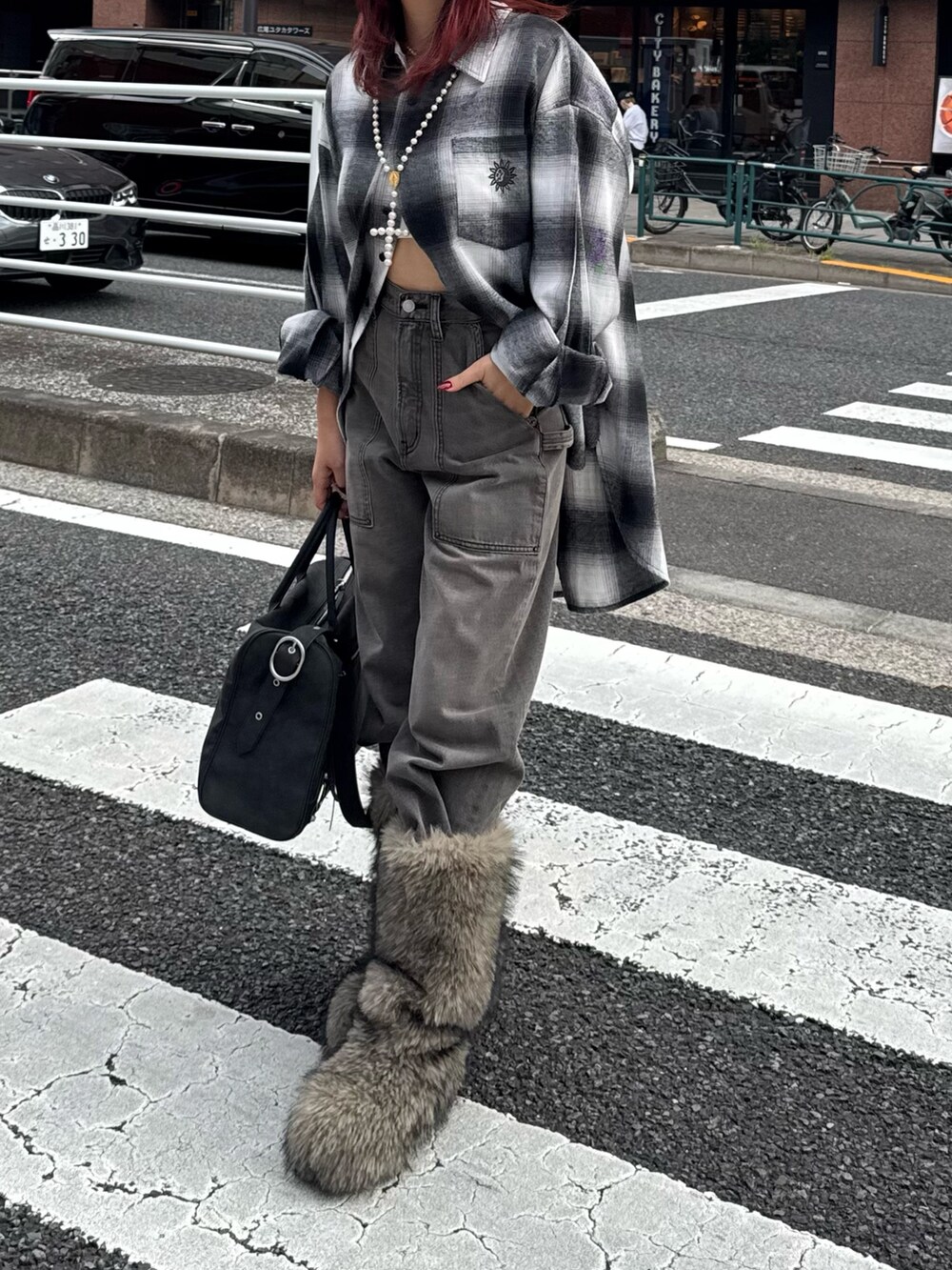 ブラック系のシャツ/ブラウス、ブラック系のデニムパンツ、ベージュ系のブーツを着用したレディースの秋コーディネートの3枚目の写真