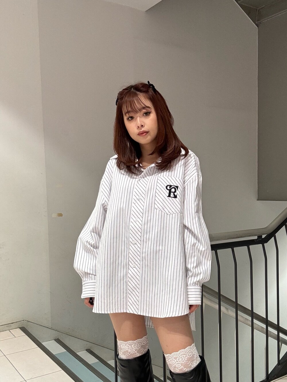 ホワイト系のシャツ/ブラウス、ブラック系のブーツを着用したレディースの冬コーディネートの3枚目の写真