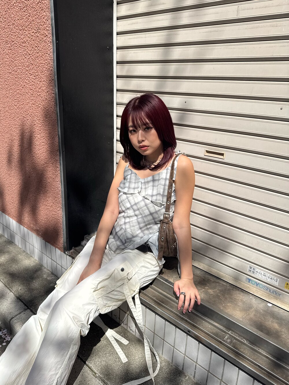 イエロー系のキャミソール、ホワイト系のカーゴパンツ、ホワイト系のパンプスを着用したレディースの春コーディネートの4枚目の写真