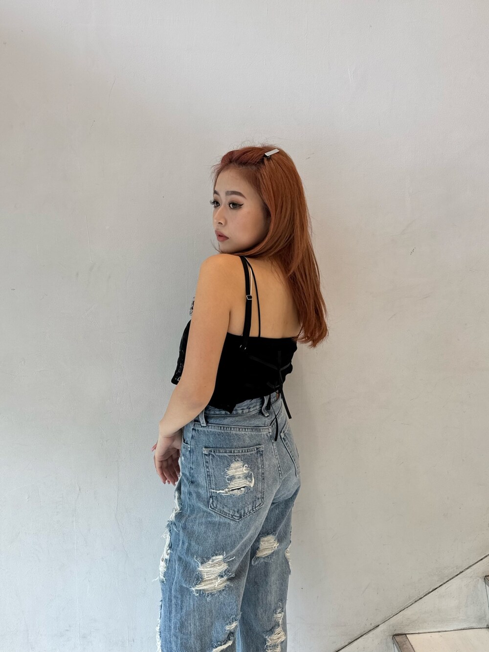 ブラック系のキャミソール、ブラック系のキャミソール、ブルー系のデニムパンツを着用したレディースの春コーディネートの3枚目の写真