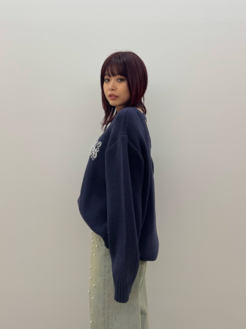 ブラック系のブーツ、ブルー系のニット/セーター、ブルー系のデニムパンツを着用したレディースの冬コーディネートの5枚目の写真