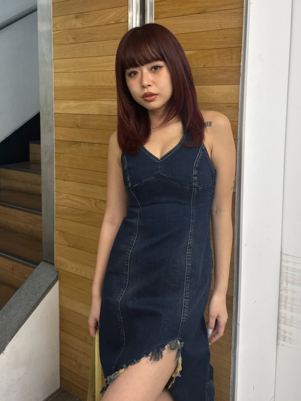 ブルー系のワンピース、イエロー系のハンドバッグ、ホワイト系のサンダルを着用したレディースの春コーディネートの4枚目の写真