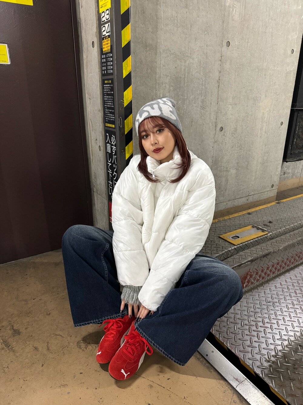 グレー系のニット/セーター、ホワイト系のブルゾン、ブルー系のデニムパンツを着用したレディースの秋コーディネートの4枚目の写真