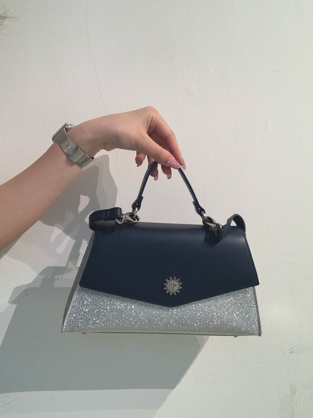 グレー系のチューブトップ、ブルー系のデニムパンツ、シルバー系のショルダーバッグを着用したレディースの春コーディネートの7枚目の写真