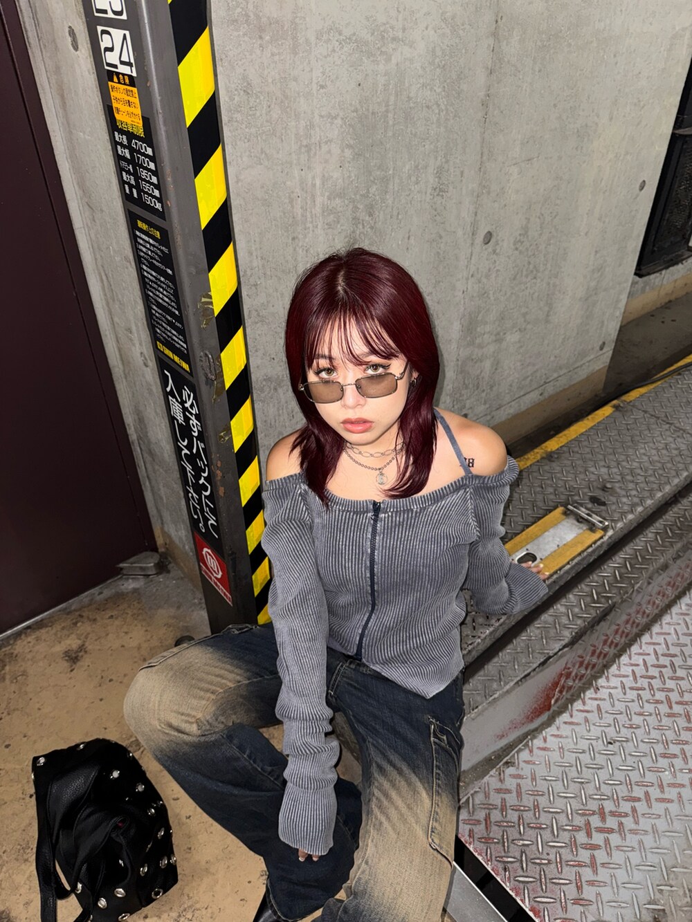 ブルー系のニット/セーター、ブルー系のデニムパンツ、ブラック系のパンプスを着用したレディースの夏コーディネートの5枚目の写真