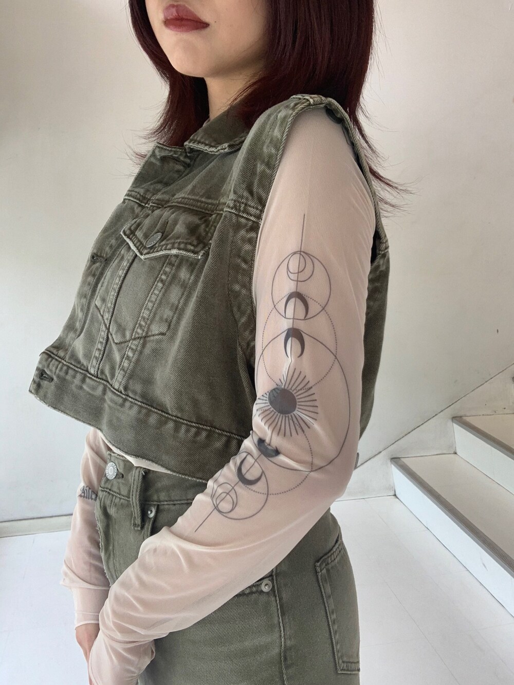 グリーン系のデニムジャケット、グリーン系のデニムスカート、ベージュ系のTシャツ/カットソーを着用したレディースの秋コーディネートの4枚目の写真