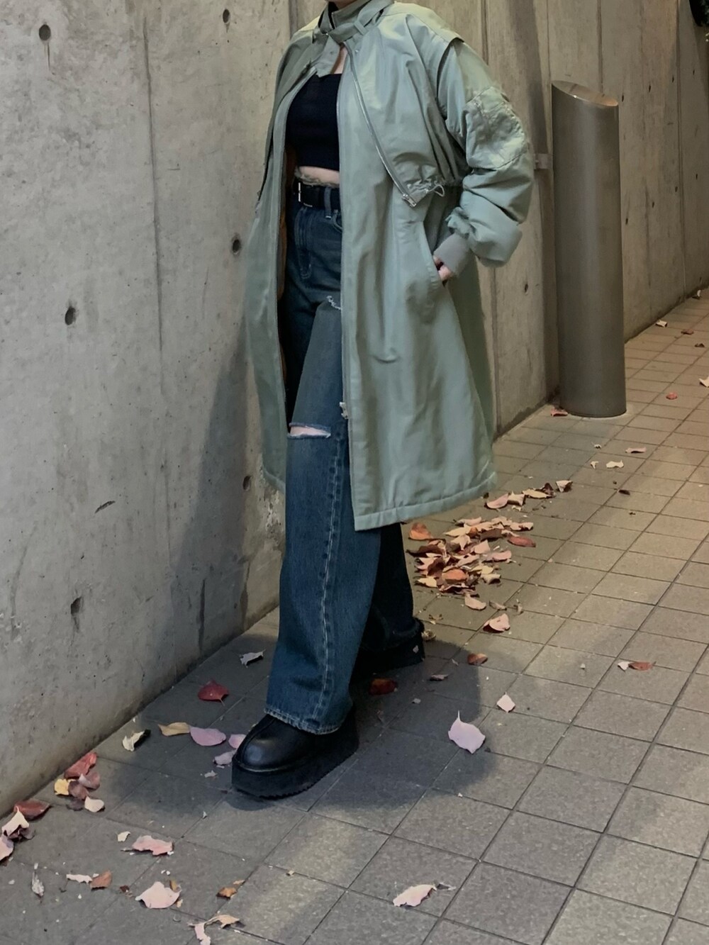 グリーン系のMA-1、ブルー系のデニムパンツ、ブラック系のスリッポンを着用したレディースの冬コーディネートの4枚目の写真