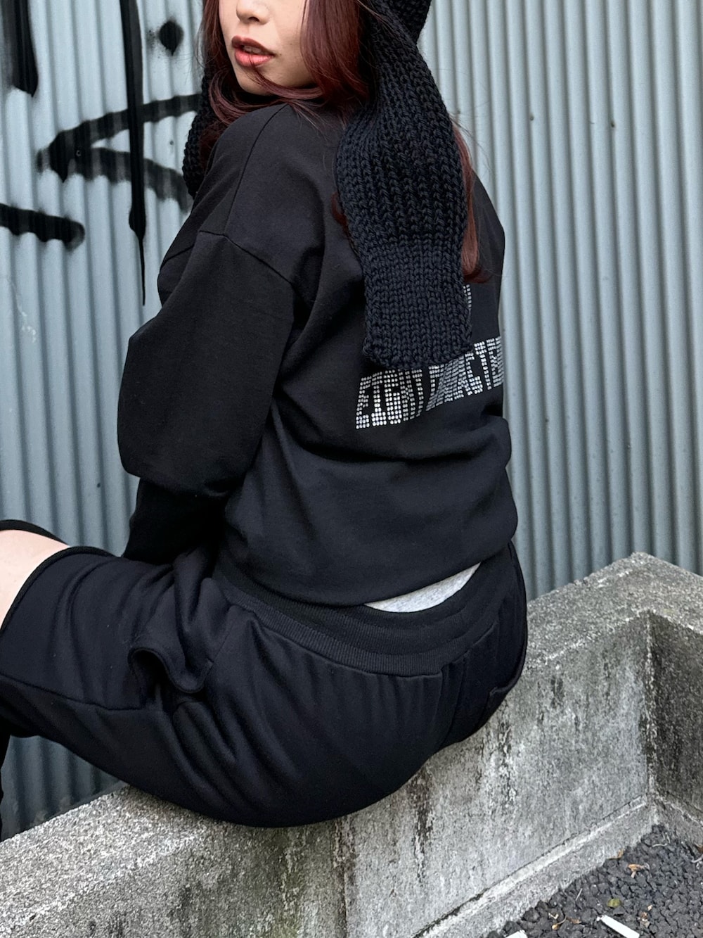 ブラック系のTシャツ/カットソー、ブラック系のスウェットパンツ、ブラック系のブーツを着用したレディースの冬コーディネートの4枚目の写真