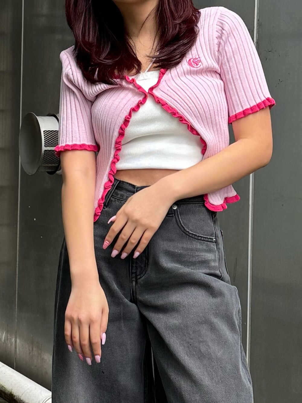 ホワイト系のキャミソール、ピンク系のカーディガン/ボレロ、ブラック系のデニムパンツを着用したレディースの春コーディネートの3枚目の写真