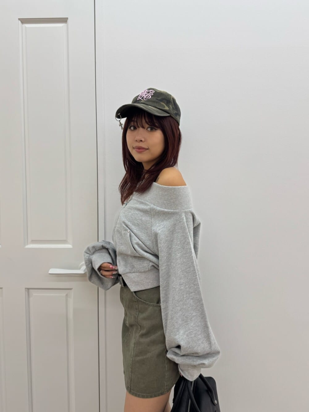 ブラック系のボストンバッグ、ブラック系のブーツ、グレー系のスウェットを着用したレディースの冬コーディネートの5枚目の写真