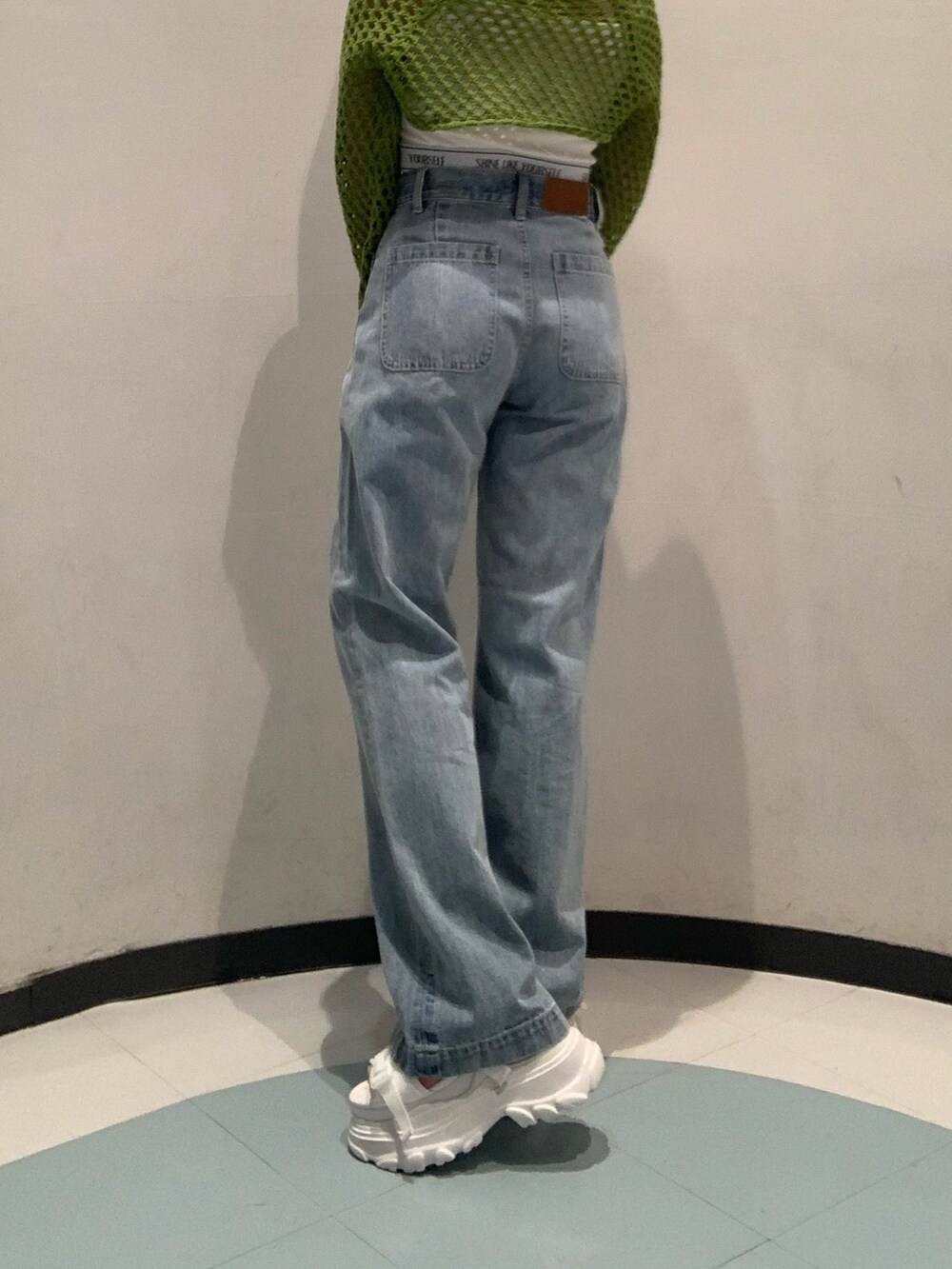 ホワイト系のサンダル、ブルー系のデニムパンツ、ホワイト系のキャミソールを着用したレディースの春コーディネートの7枚目の写真