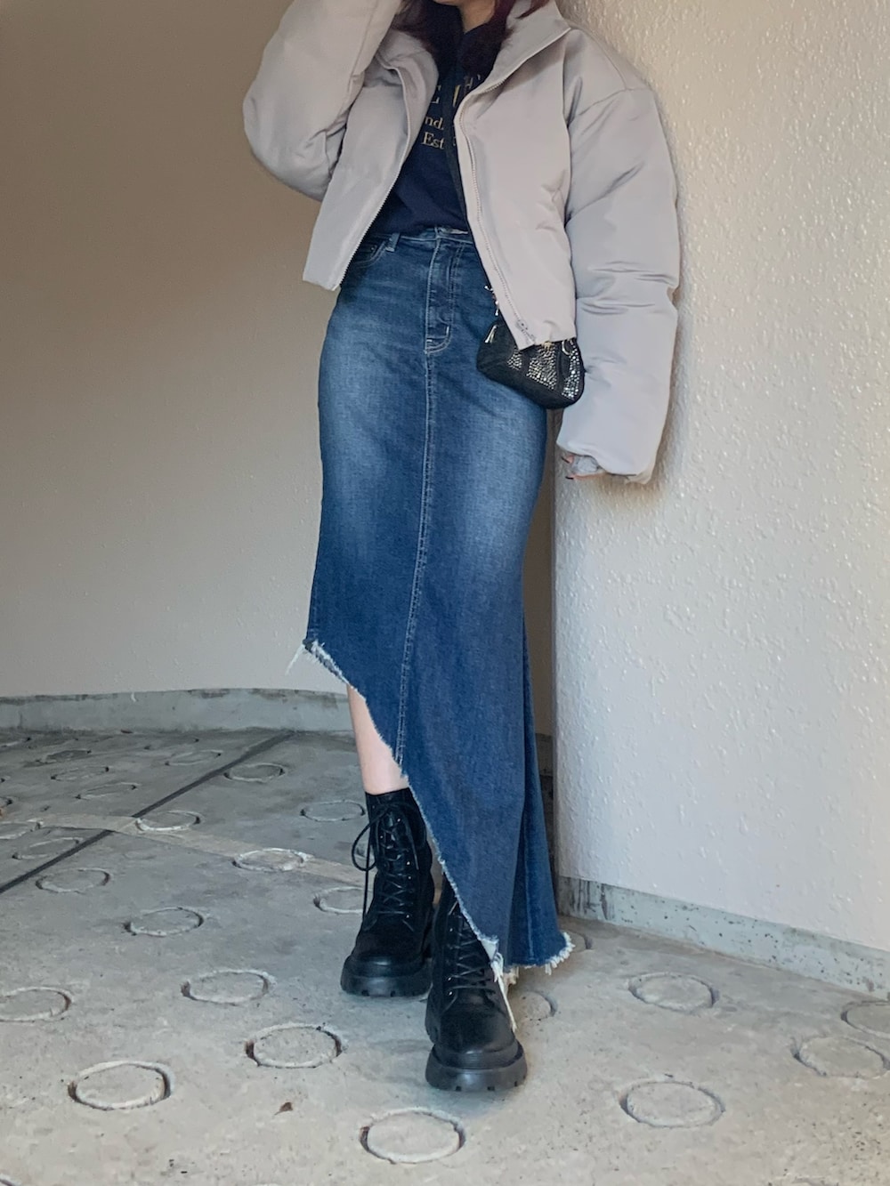 ブラック系のハンドバッグ、ブルー系のスウェット、グレー系のダウンジャケット/コートを着用したレディースの冬コーディネートの2枚目の写真