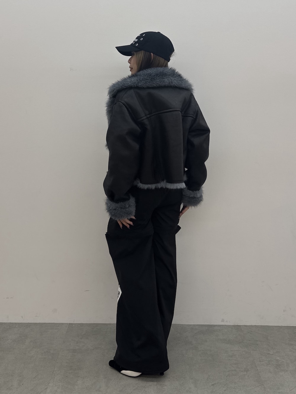 ブラック系のカーゴパンツ、ブラック系のスニーカー、ブラック系のパーカーを着用したレディースの秋コーディネートの3枚目の写真