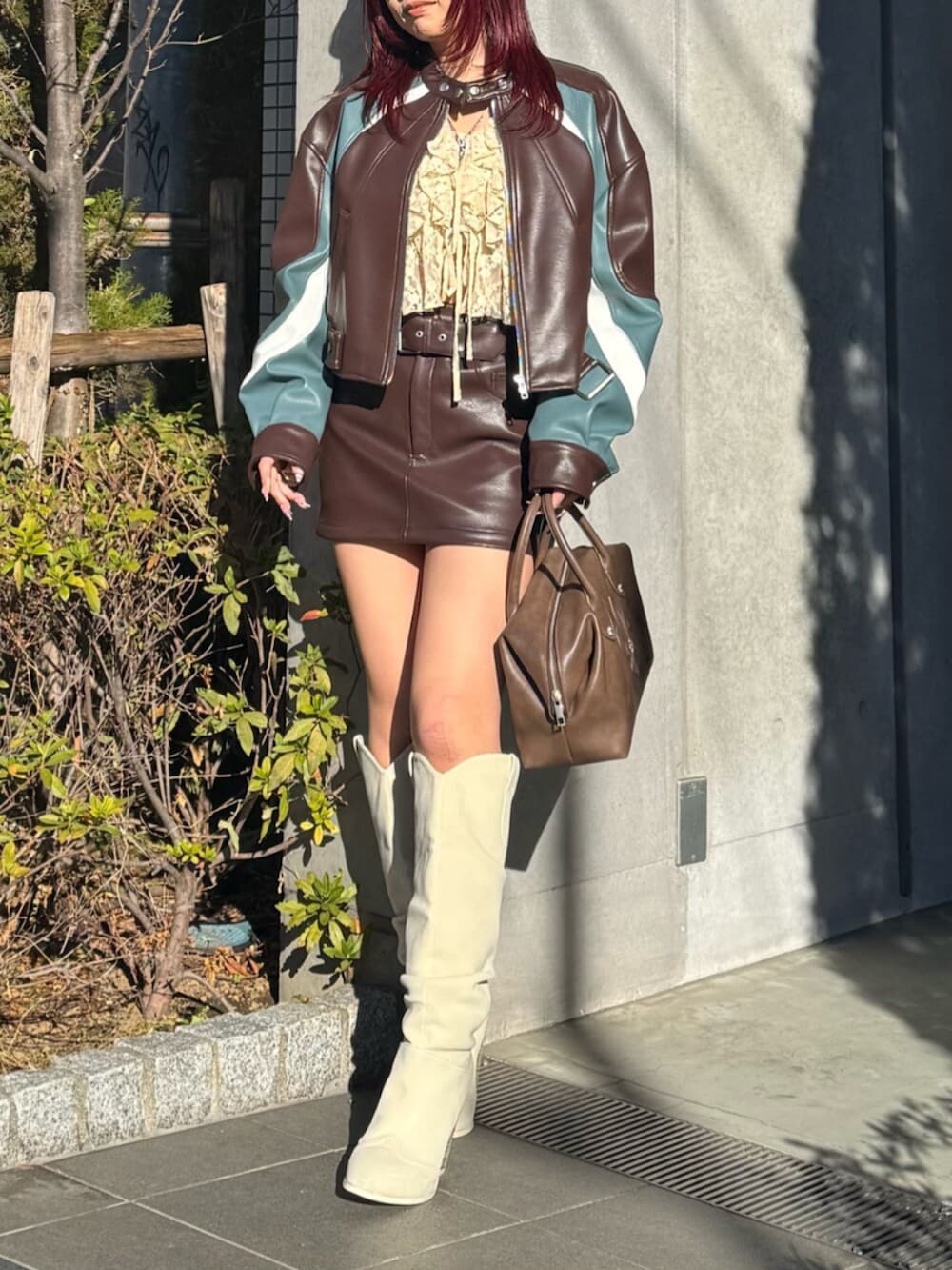 ベージュ系のシャツ/ブラウス、ブラウン系のボストンバッグ、ホワイト系のブーツを着用したレディースの冬コーディネートの2枚目の写真