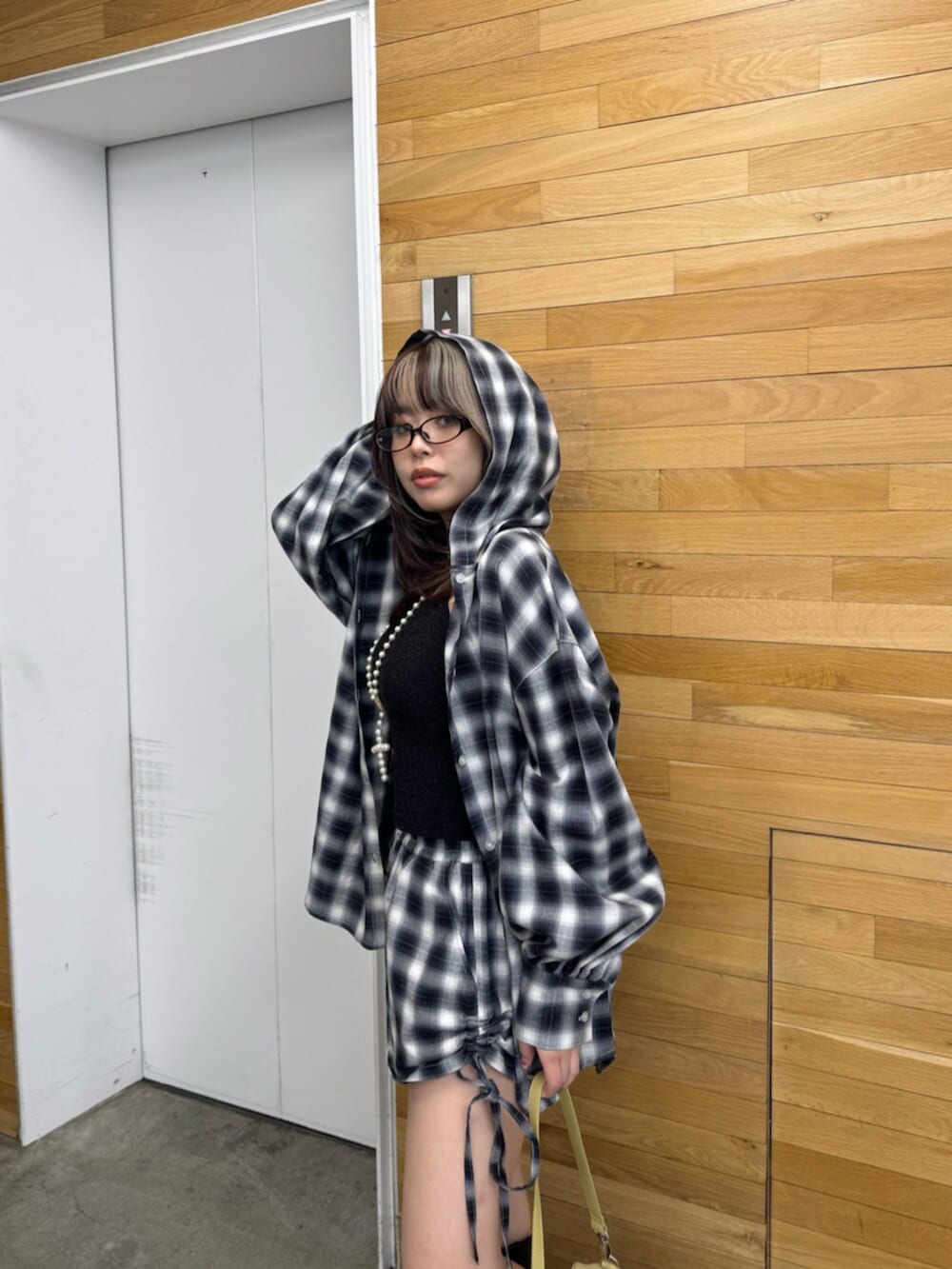 イエロー系のハンドバッグ、ブラック系のシャツ/ブラウス、ブラック系のその他パンツを着用したレディースの春コーディネートの5枚目の写真