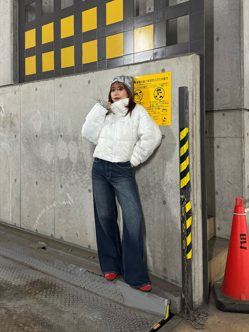 グレー系のニット/セーター、ホワイト系のブルゾン、ブルー系のデニムパンツを着用したレディースの秋コーディネートの2枚目の写真