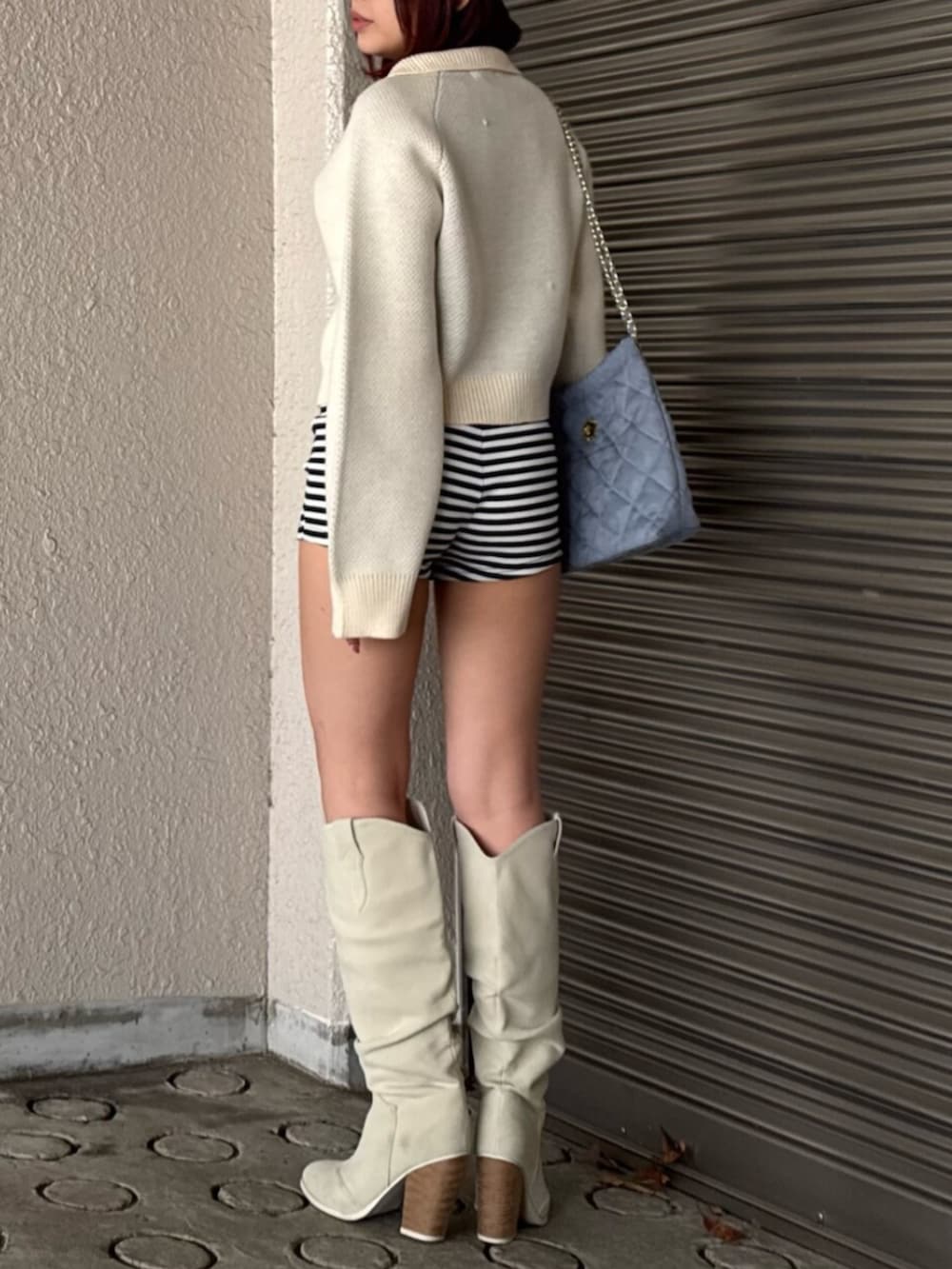 ホワイト系のニット/セーター、ホワイト系のブーツを着用したレディースの冬コーディネートの3枚目の写真