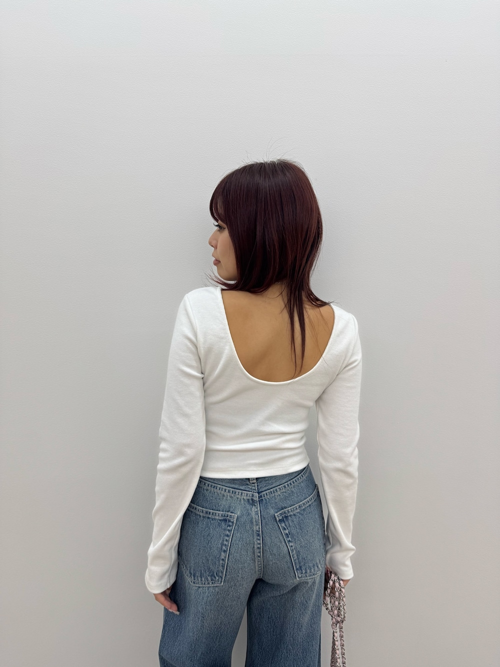 ホワイト系のTシャツ/カットソー、ブルー系のデニムパンツ、ピンク系のショルダーバッグを着用したレディースの冬コーディネートの4枚目の写真