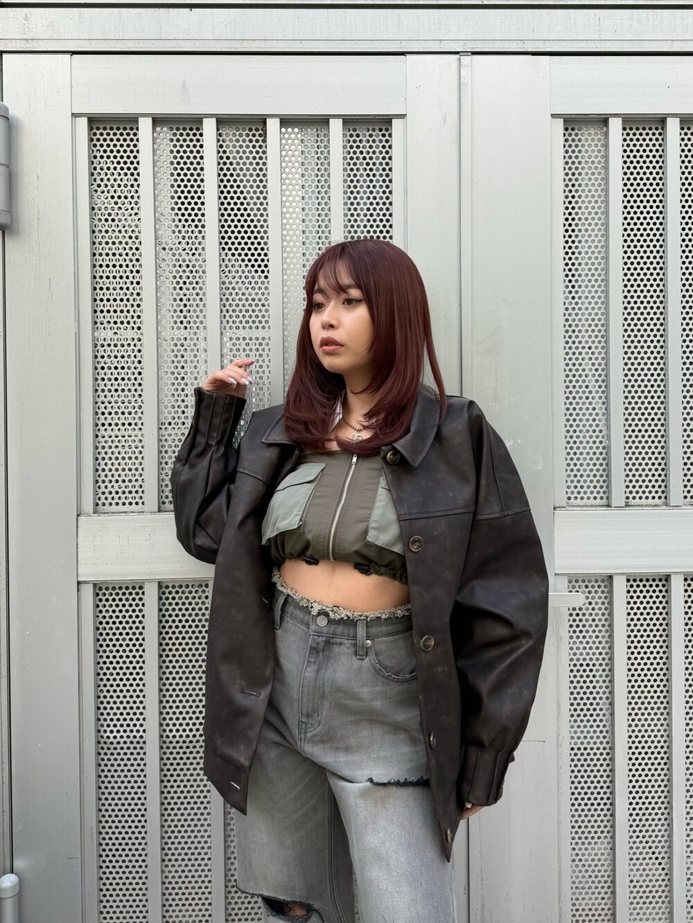 ブラウン系のブルゾン、グリーン系のキャミソール、ブラック系のデニムパンツを着用したレディースの冬コーディネートの3枚目の写真