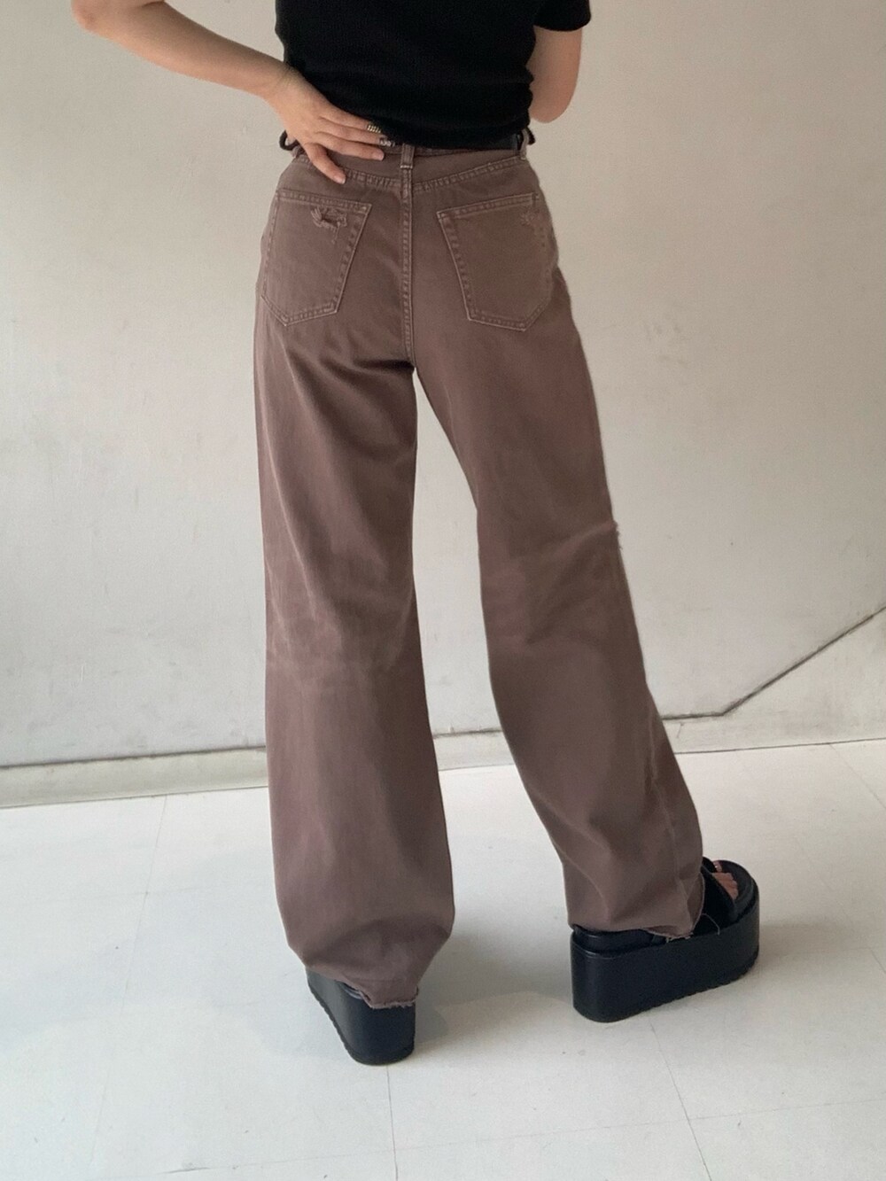 ブラック系のTシャツ/カットソー、ブラック系のサンダル、ブラウン系のデニムパンツを着用したレディースの夏コーディネートの5枚目の写真